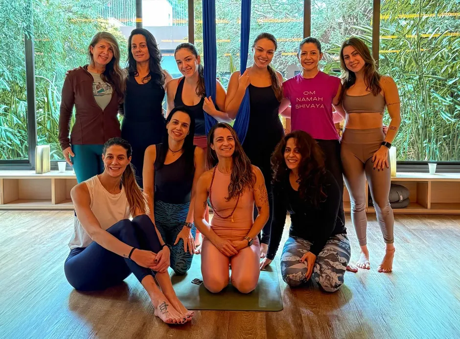 Fê Tavares orientando aluna em capacitação de yoga aéreo