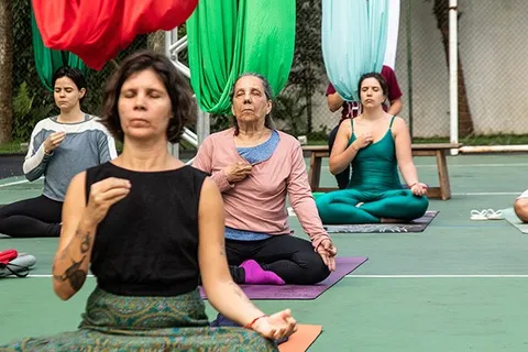 Fê Tavares e alunas em prática de yoga aéreo