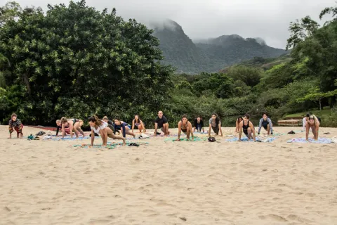 Fê Tavares e alunas em prática de yoga aéreo