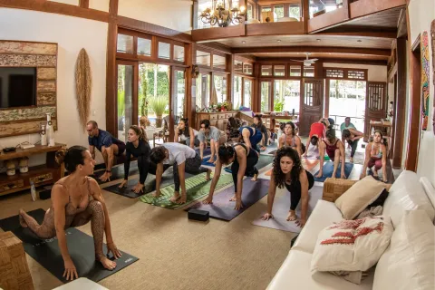 Fê Tavares e alunas em prática de yoga aéreo